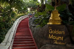 BANGKOK, THAILAND – APRIL 13, 2022: Wat Saket is a Temple with a beautiful view of Bangkok. 344 stairs lead to the top of the Golden Mountain. Beautiful Tropical Garden near the stairs.