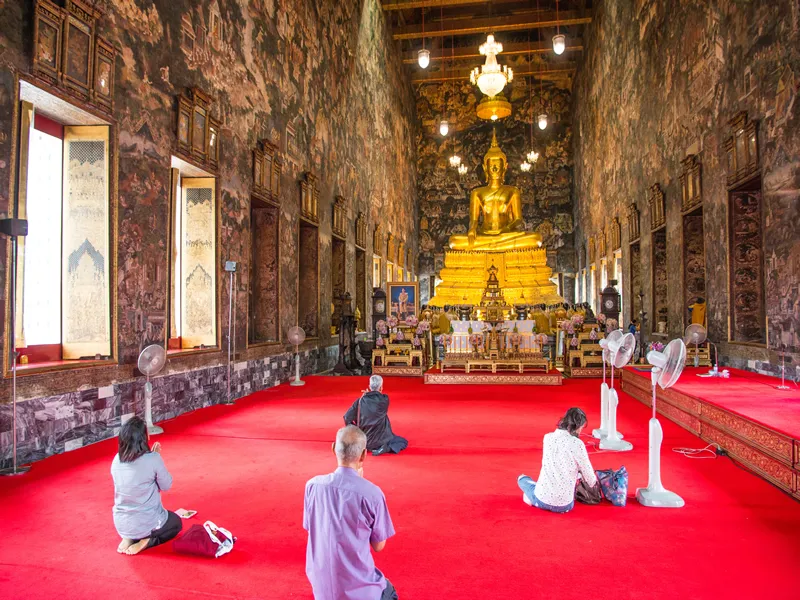 BANGKOK, THAILAND, MAY 16, 2017: People praying inside Ordinations hall of Wat Suthat Thepphawararam, Bangkok, Thailand