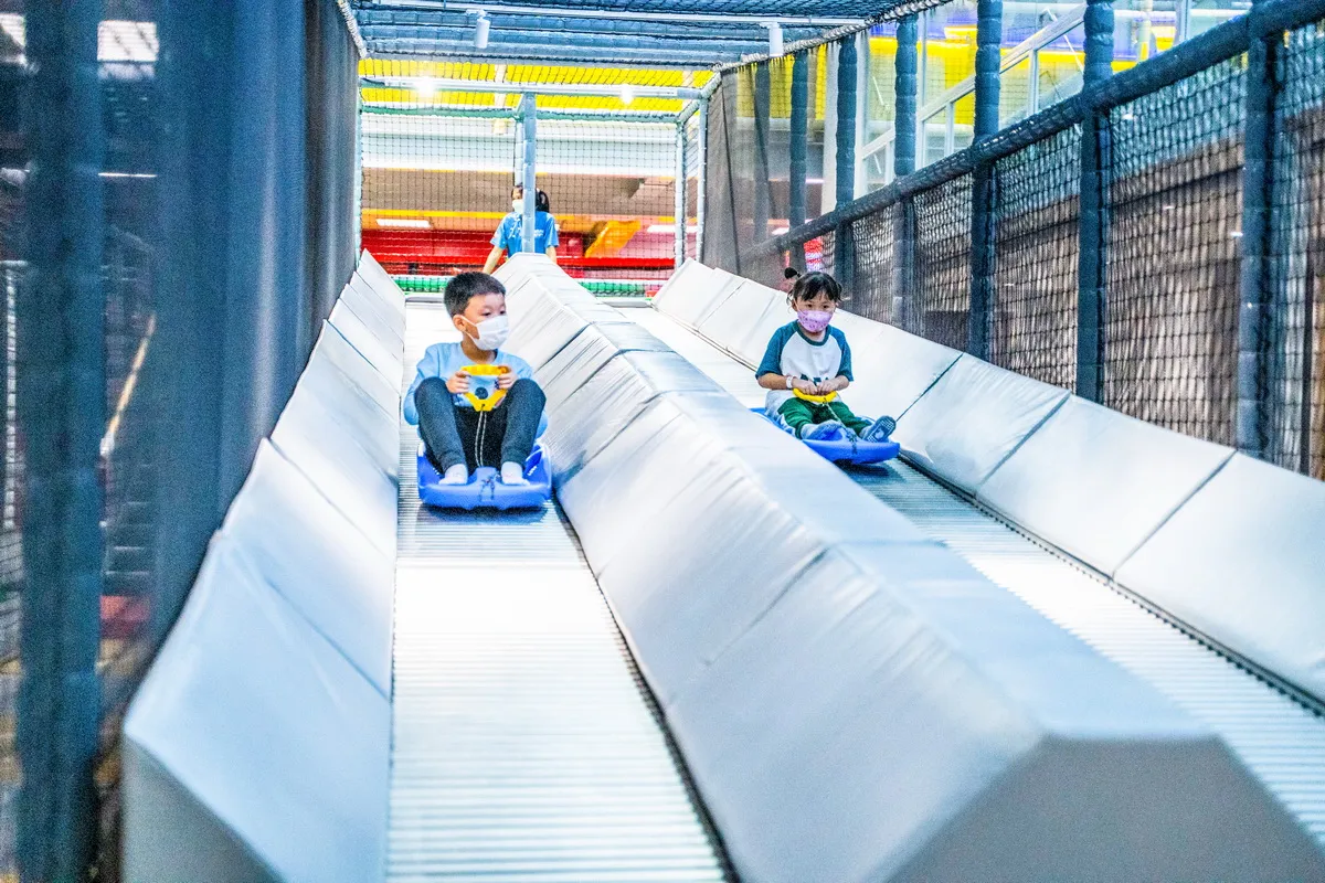 2 Children racing down the indoor race track at HorborLand at IconSiam in Bangkok