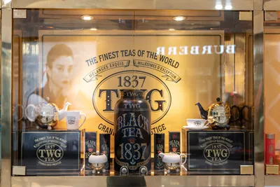 TWG tea salon and boutique cafe in Emporium shopping mall, Bangkok, Thailand, Feb 3, 2019 : Shop display with golden yellow decoration.