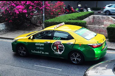 Bangkok, Thailand, April 11, 2024: A taxi on the road painted with an advertisement of Punthai coffee